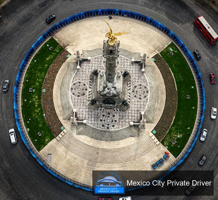 The intricate details of the Ángel de la Independencia monument, showcasing its golden angel atop a tall column against a clear blue sky.